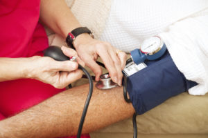 Nurse taking a patient's blood pressure using a sphygmomanometer. Closeup view.