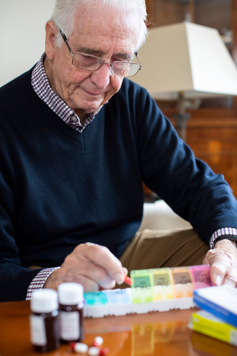 A senior receiving a gentle medication reminder from a caregiver, ensuring they take their prescriptions on time for better health and well-being.