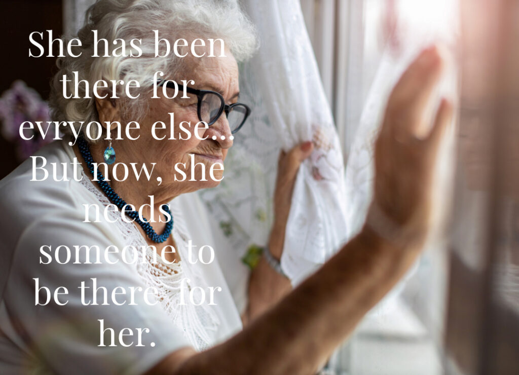 Older woman sitting thoughtfully by a window representing aging, caregiving, and navigating care decisions for loved ones at home.